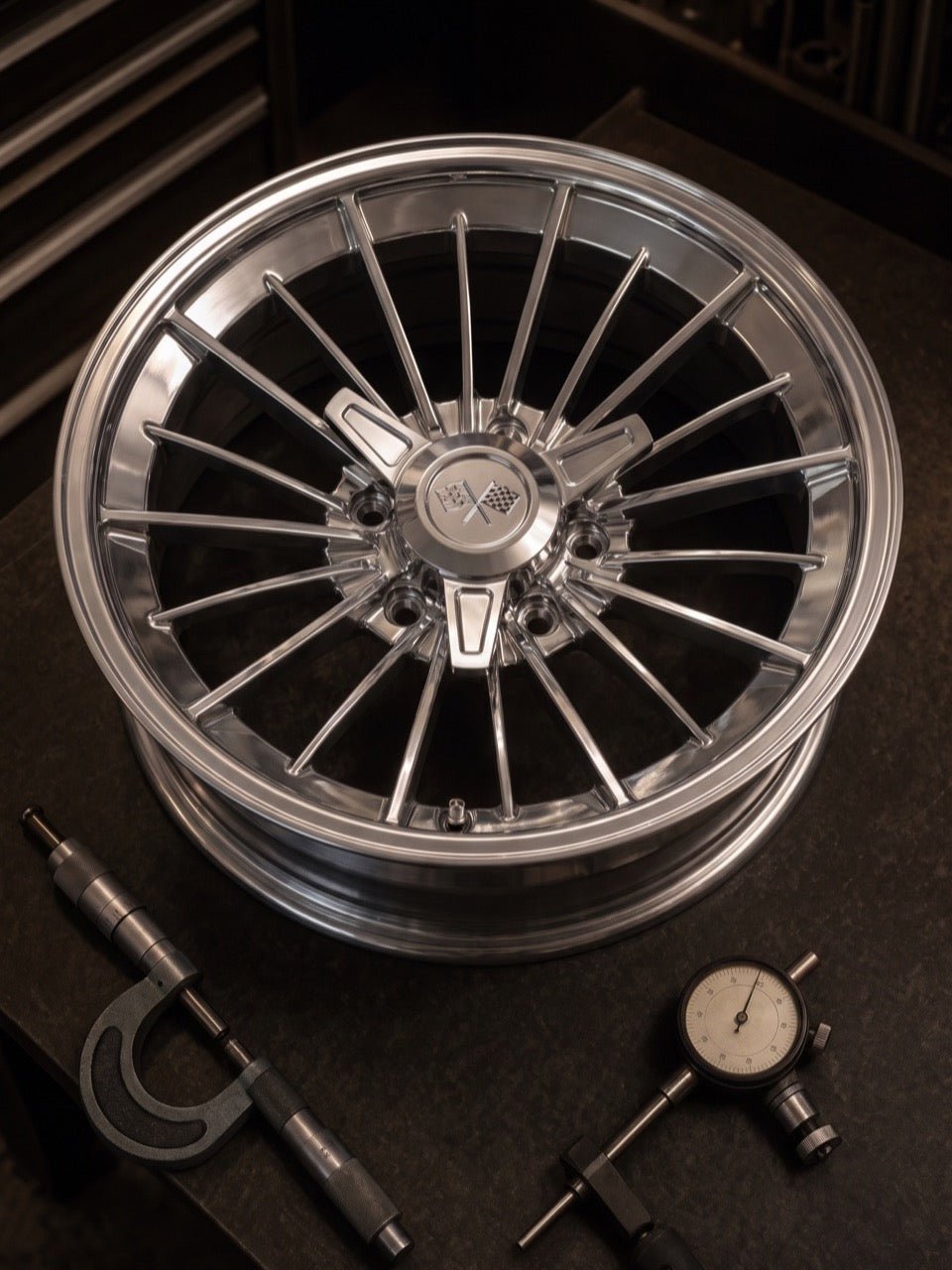 A polished Stripper 17-inch forged wheel on the inspection bench beside a micrometer and dial gauge
